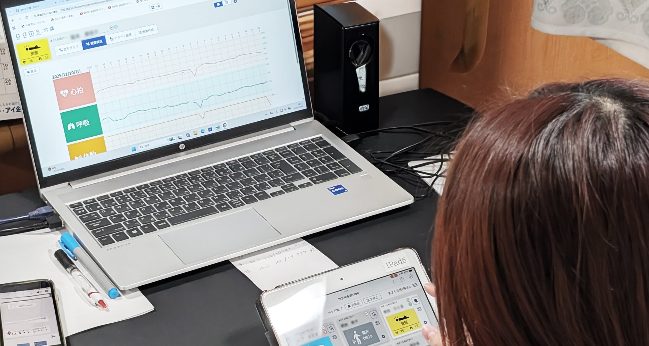 介護施設で記録業務や情報共有を行うスタッフの様子